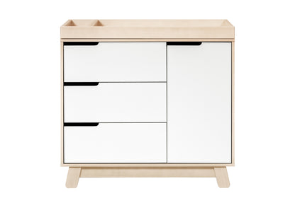 Modern light wood baby changing table dresser with three drawers and a cabinet, featuring black handles.