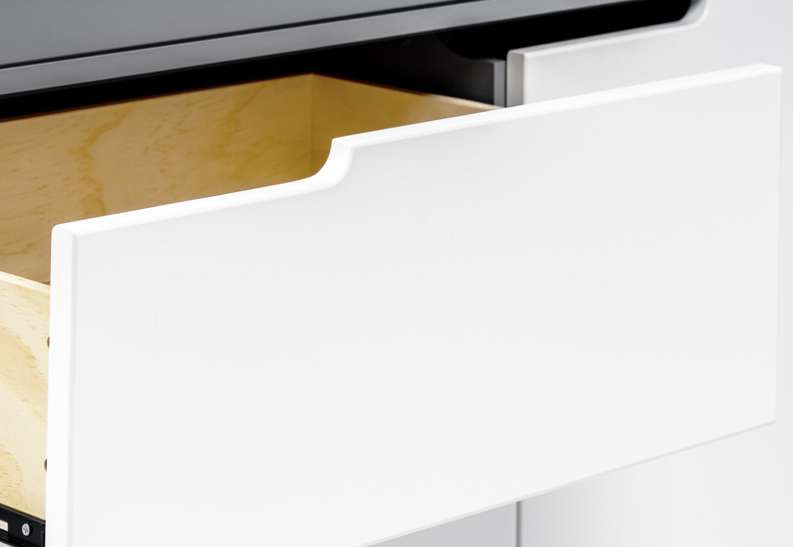 Close-up of a white drawer partially opened, showing its sleek design and the wooden interior of the cabinet.