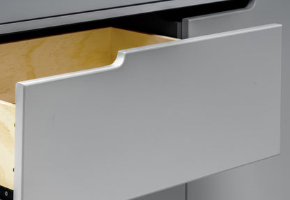 Close-up view of an open white drawer showing its contents and smooth finish ideal for a baby’s room.