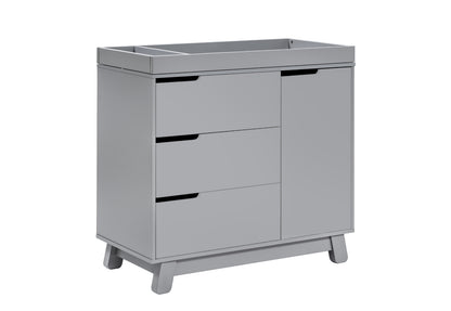 Gray baby changing table with a cabinet and three drawers on short legs.