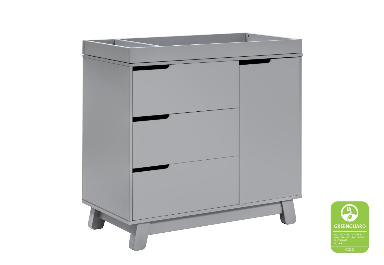 Modern gray changing table with three drawers and a door, featuring a GREENGUARD Gold certification badge for low chemical emissions.