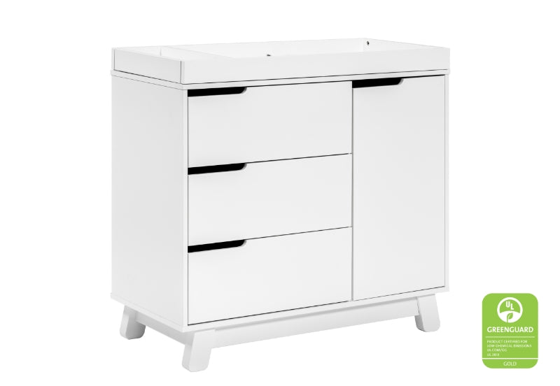 White baby changing table with three drawers and a cabinet, featuring a Greenguard Gold certification logo.