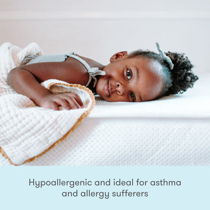 A young child lies comfortably on a bed with a Newton Baby Kids' Twin Mattress. Text at the bottom reads: GREENGUARD Gold certified, hypoallergenic, and ideal for asthma and allergy sufferers.