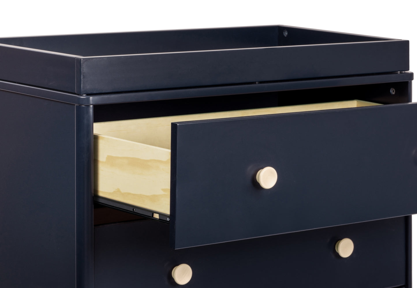 Black nursery dresser with open drawers revealing cream interiors and gold knobs.