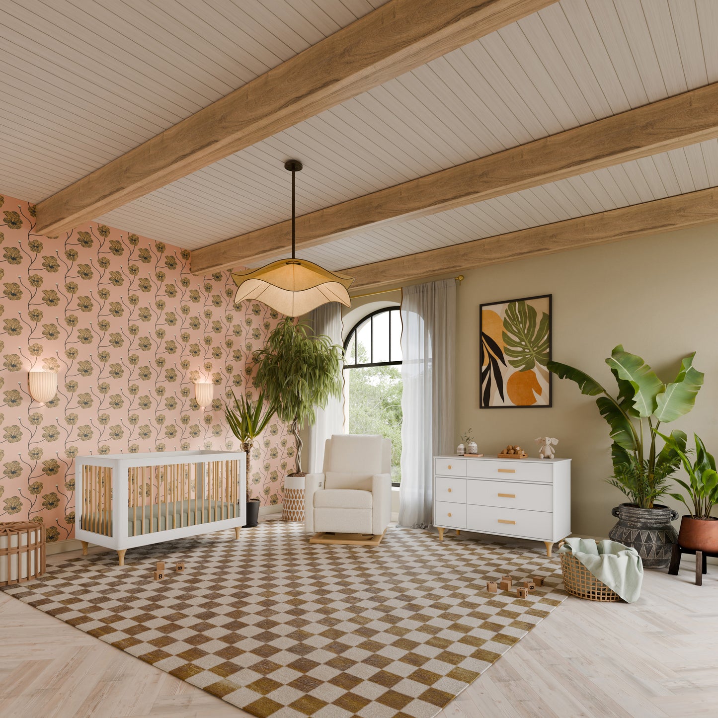 Bright nursery featuring the Babyletto Lolly Convertible Crib crafted from New Zealand pine wood, a cozy rocking chair, dresser, lush plants, and playful wallpaper. Wooden ceiling beams and a checkered rug enhance the modern, inviting space, with toys and a wicker basket arranged on the floor.