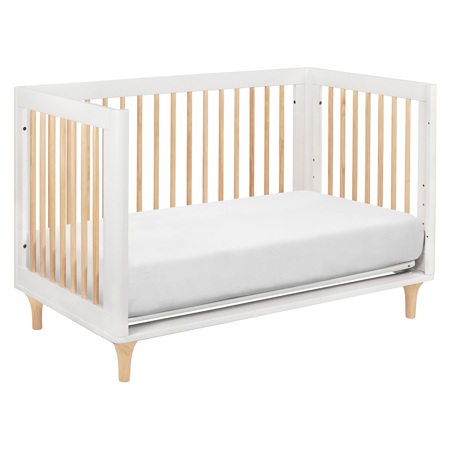 The Babyletto Lolly Convertible Crib showcases a minimalist design with white and natural New Zealand pine wood slats, a sleek white frame, and angled wooden legs. Complete with a white mattress and the versatility to convert as your child grows, this crib perfectly blends style and function—embodying Babyletto’s signature modern aesthetic.