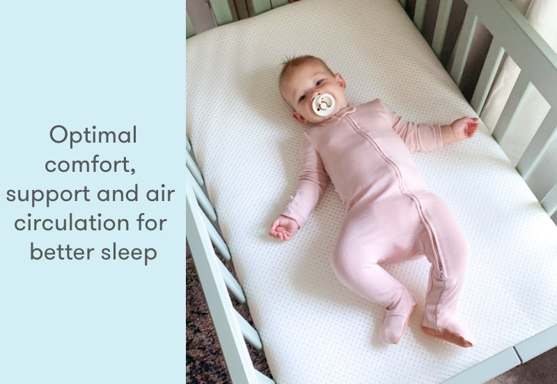 Baby in pink onesie resting on a breathable mattress in a crib, with text "Optimal comfort, support and air circulation for better sleep".