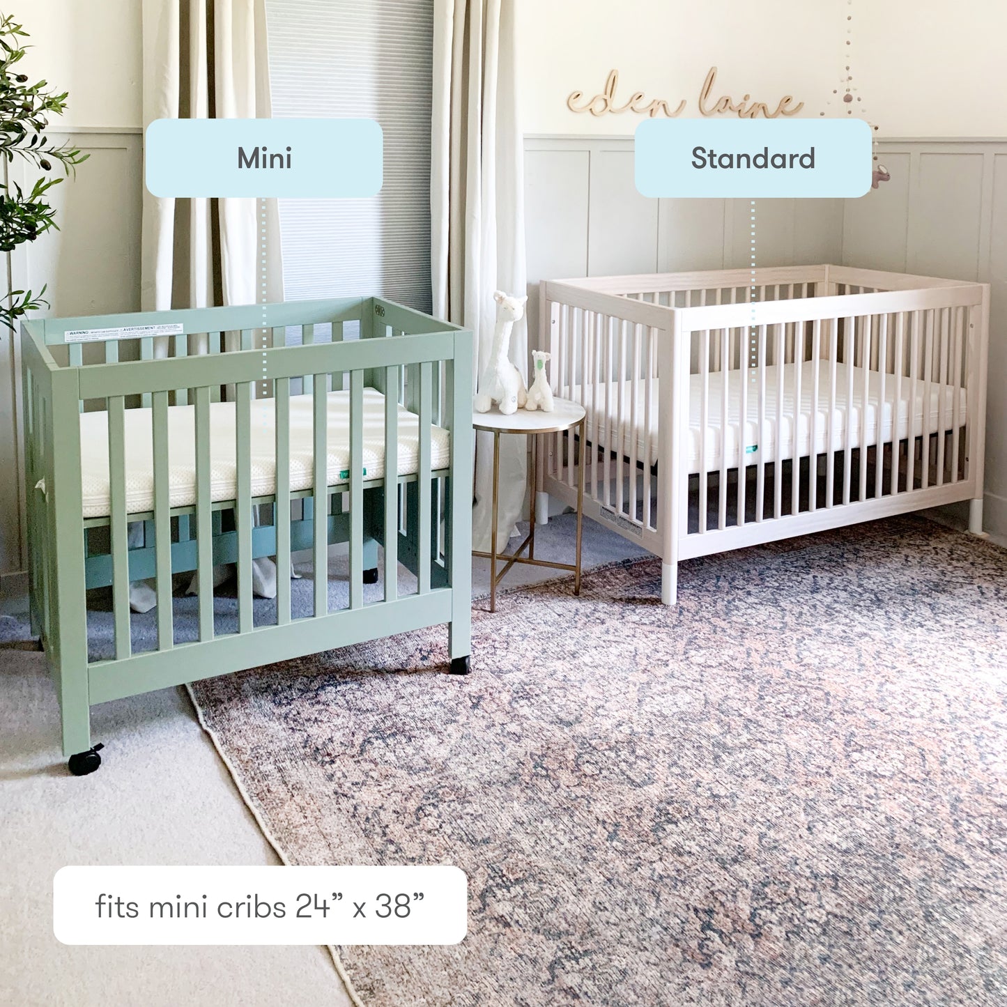 Comparison of two cribs labeled "Mini" and "Standard" in a cozy nursery room with decorative rug and elegant wall decor. 