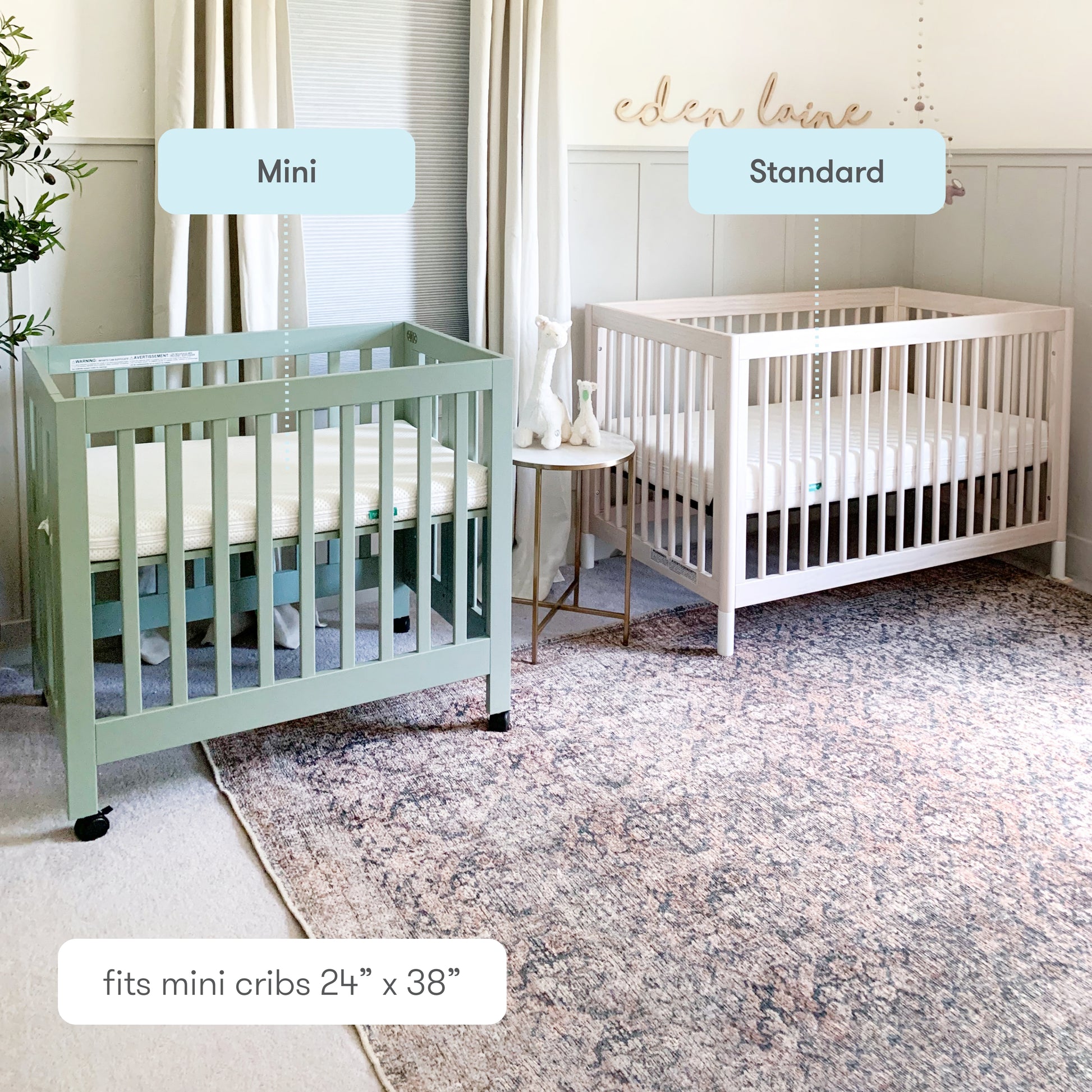 Comparison of two cribs labeled "Mini" and "Standard" in a cozy nursery room with decorative rug and elegant wall decor. 