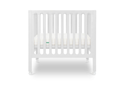 White modern crib on wheels with visible mattress, isolated on a plain background. Mattress in lowered position.