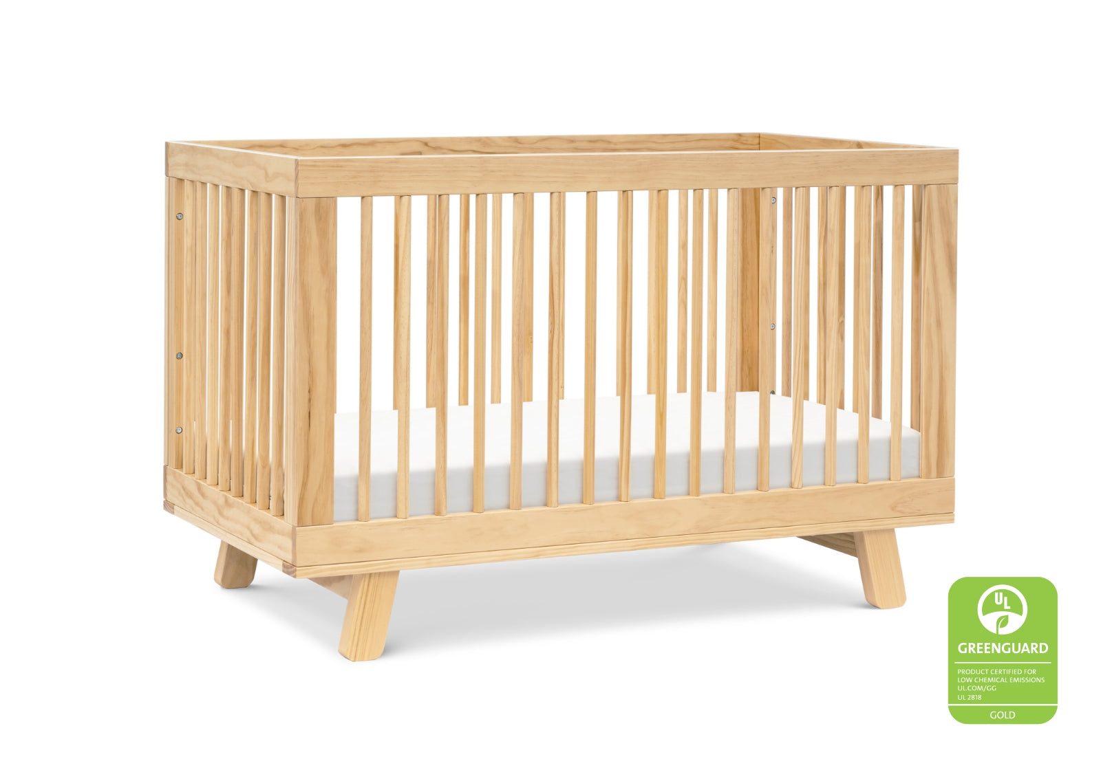 Minimalist natural wood baby crib with visible slats and a GREENGUARD Gold Certification label.