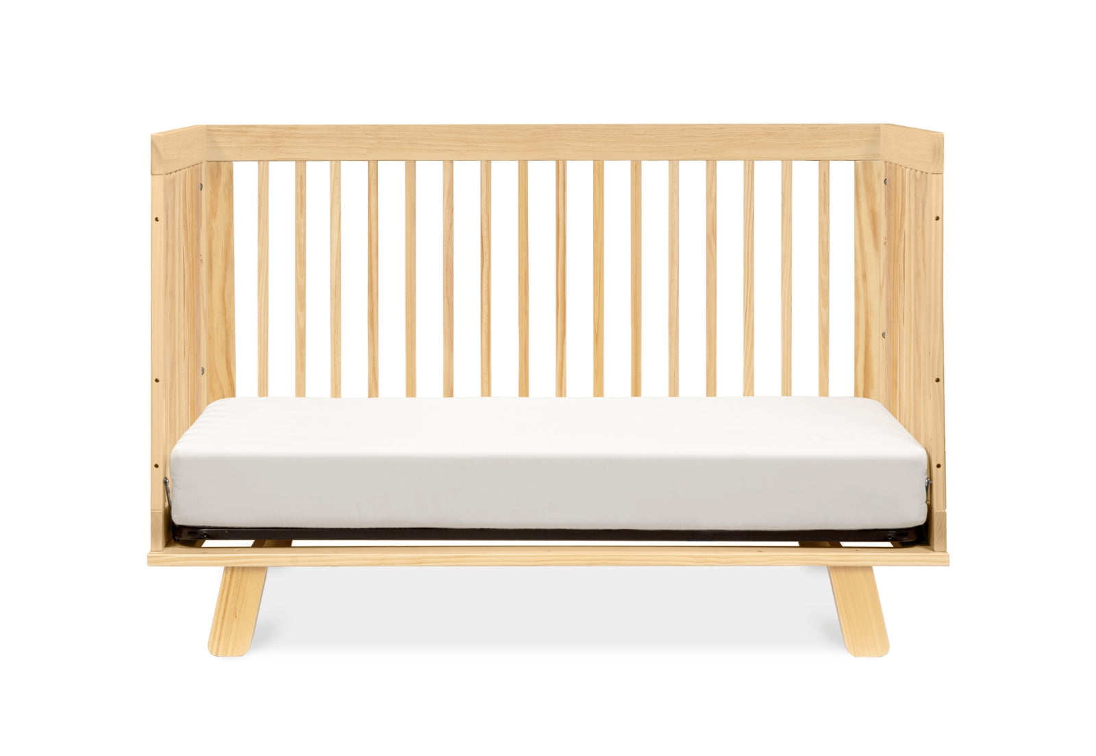 Contemporary wooden crib with a white mattress against a plain background.