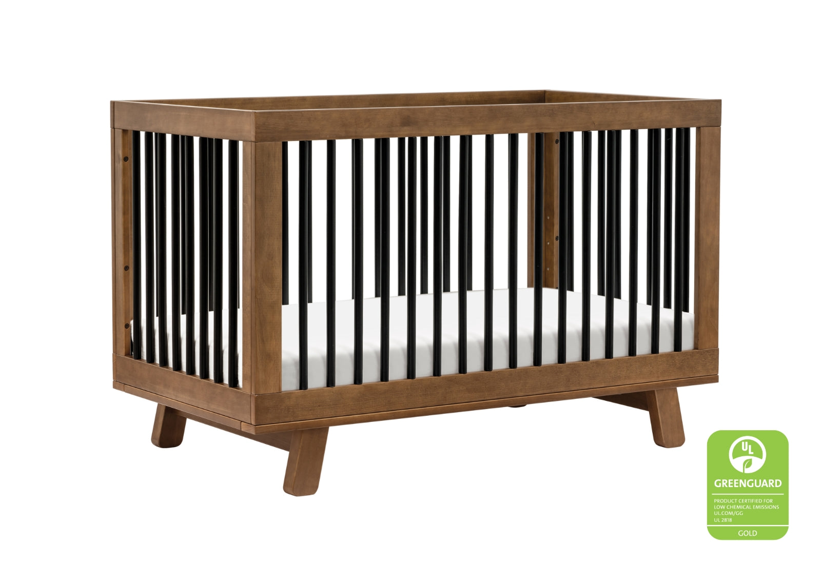 A modern wooden baby crib with visible Greenguard Gold Certification logo on a white background.
