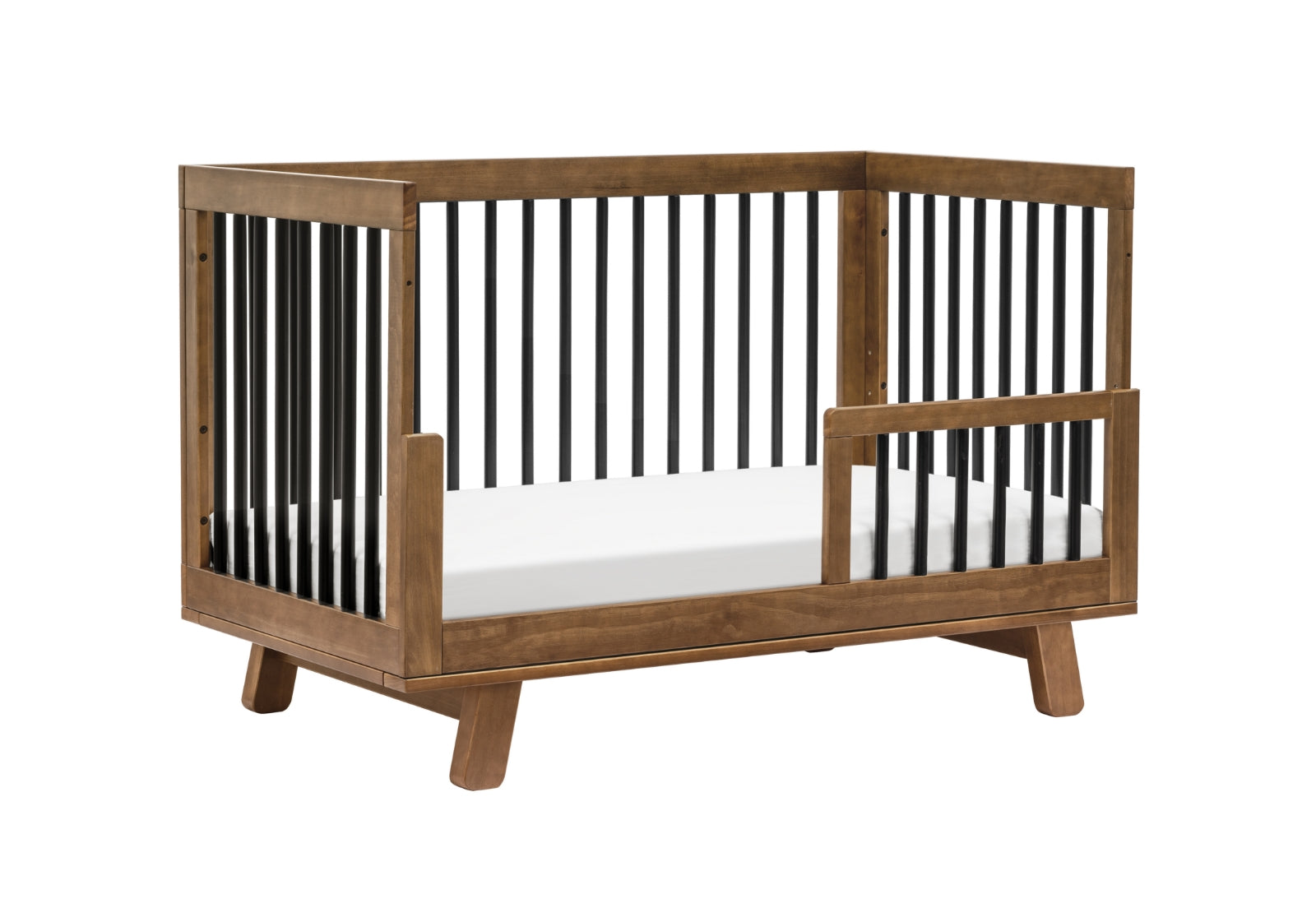Modern wooden baby crib with visible slats and a lowered side gate on a white background.