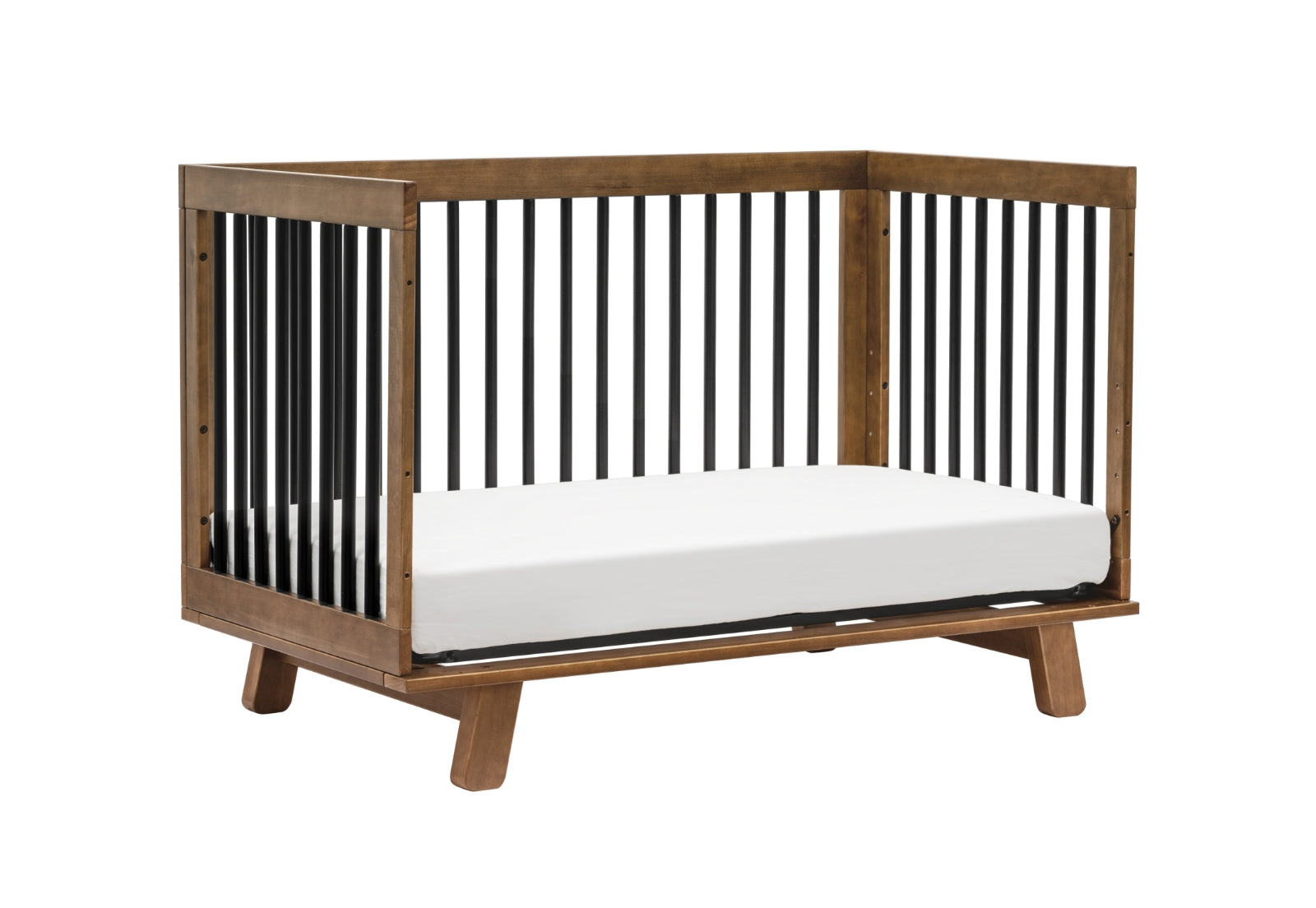 Modern wooden baby crib with a white mattress and black vertical slats on a light background.