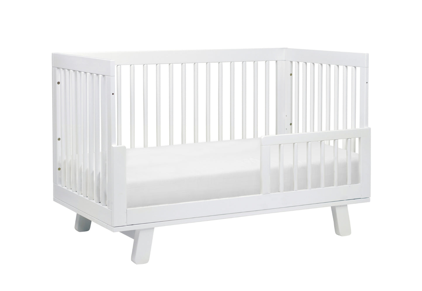 A modern white baby crib with stylish slatted design and a lowered front rail on a plain background, ideal for a contemporary nursery.