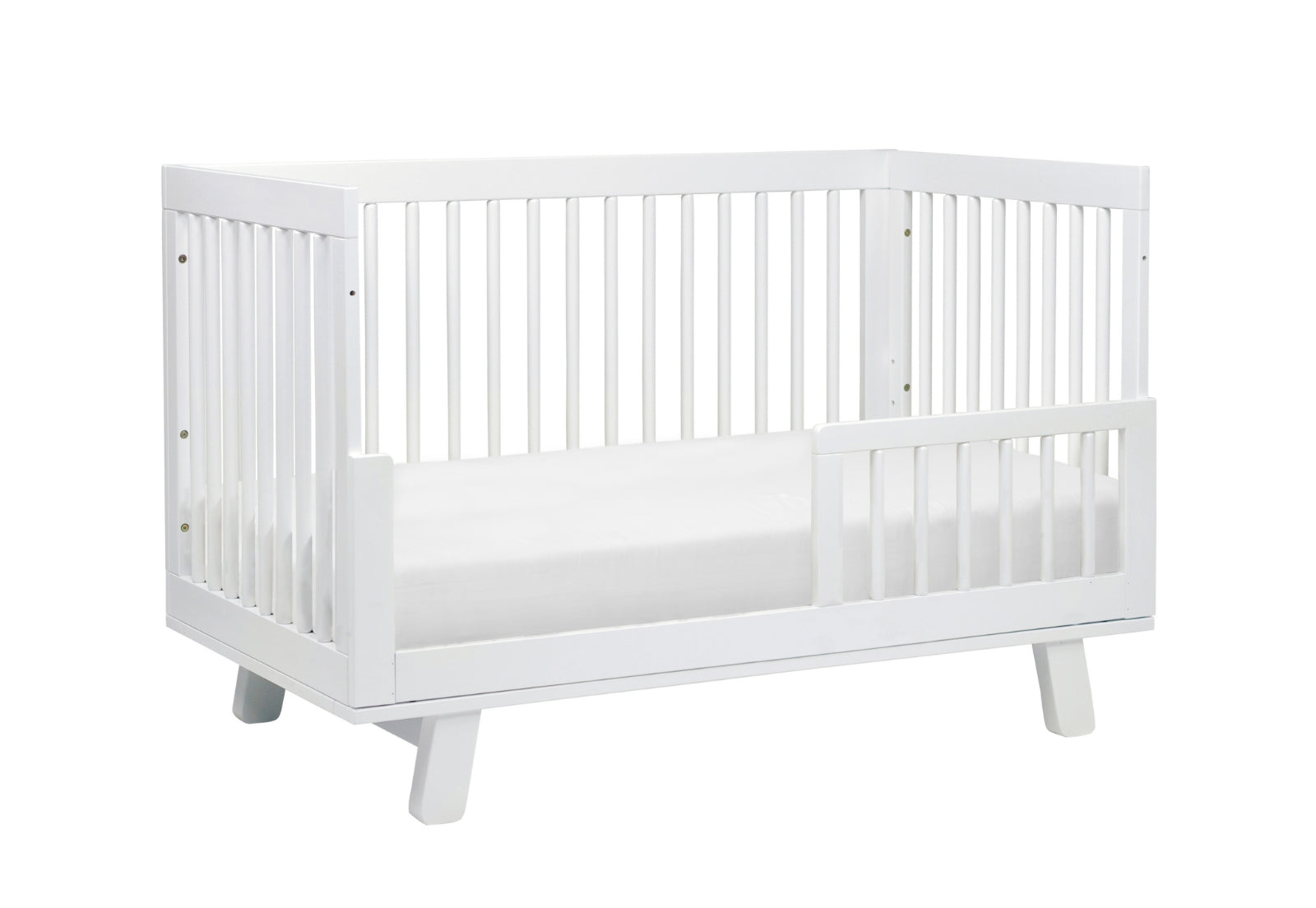 A modern white baby crib with stylish slatted design and a lowered front rail on a plain background, ideal for a contemporary nursery.