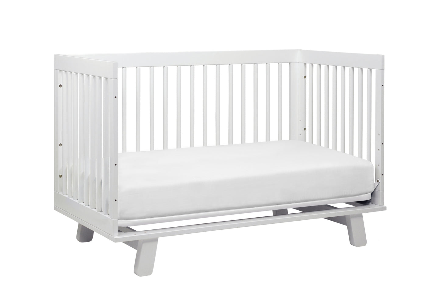 White modern baby crib with a simple design and sturdy slats on a gray base.