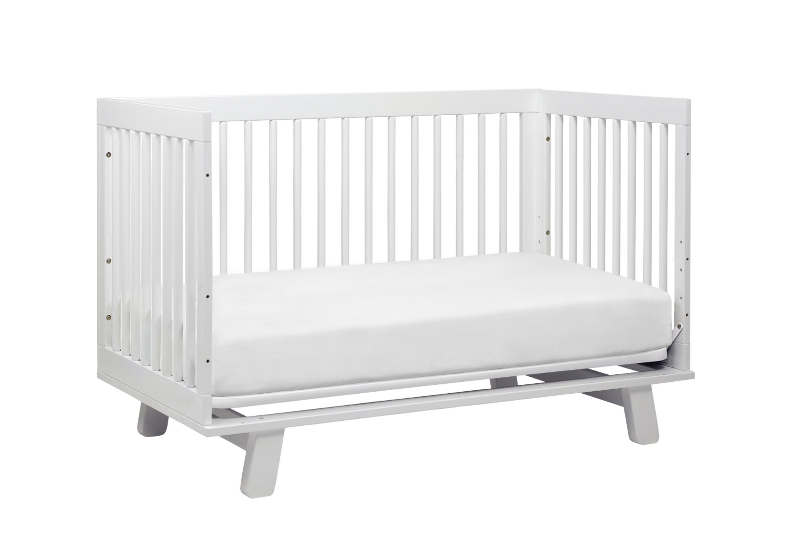White modern baby crib with a simple design and sturdy slats on a gray base.