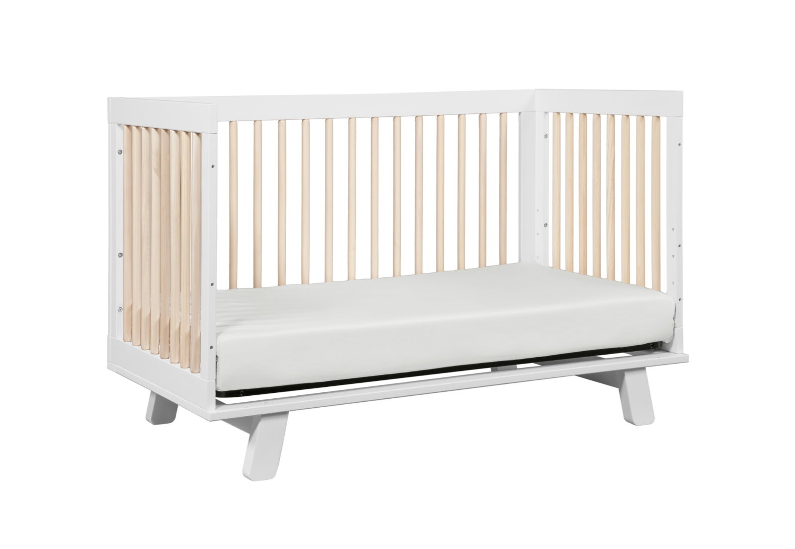 White and natural wood modern baby crib with a breathable mattress on a gray background.