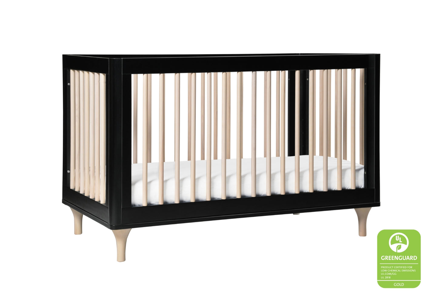 Black modern crib with white mattress and natural wood legs, featuring a GREENGUARD Gold certification logo.