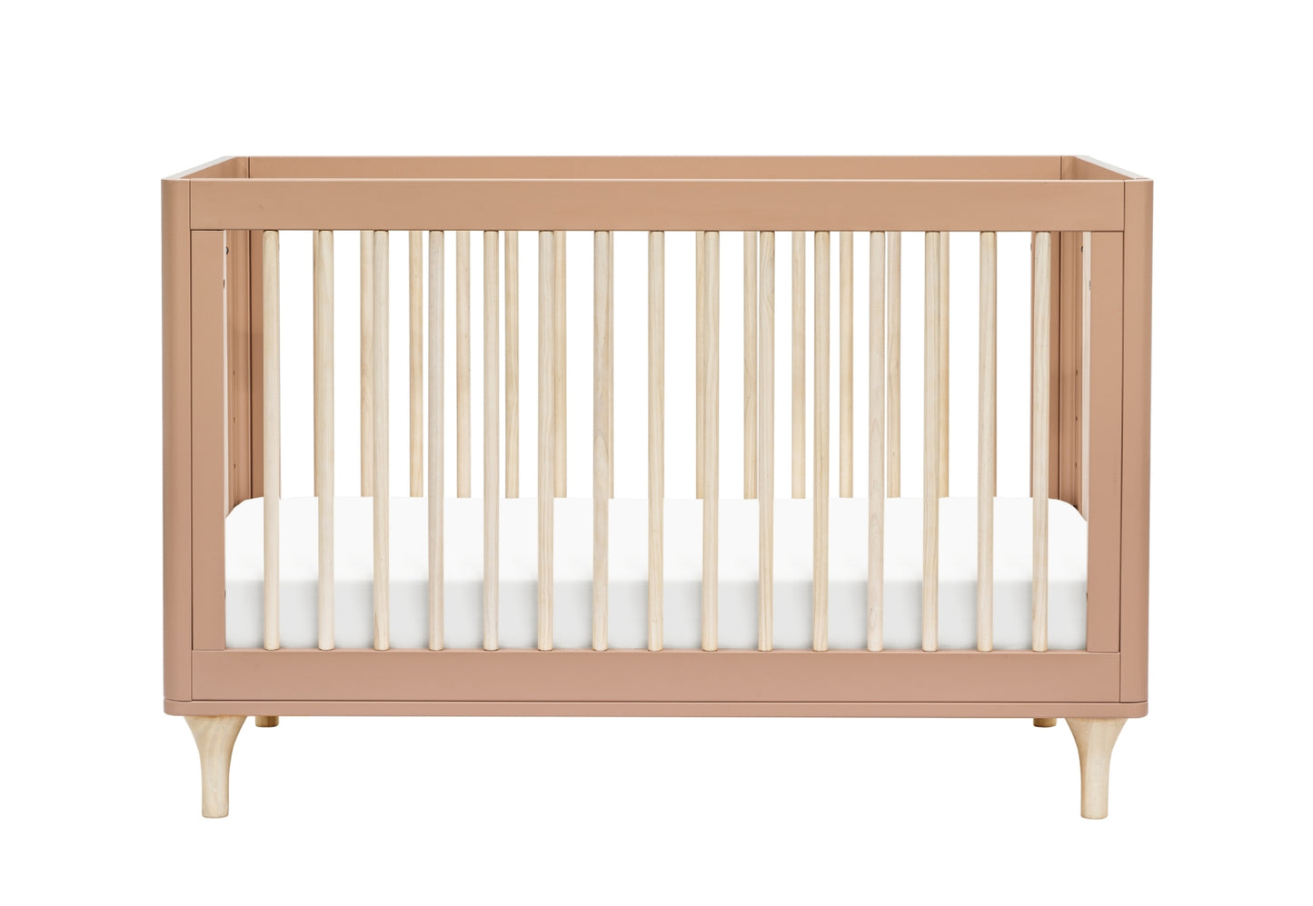 A modern blush pink crib with sturdy legs and slatted sides, shown without bedding.
