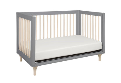 Gray modern baby crib with white mattress on a white background.