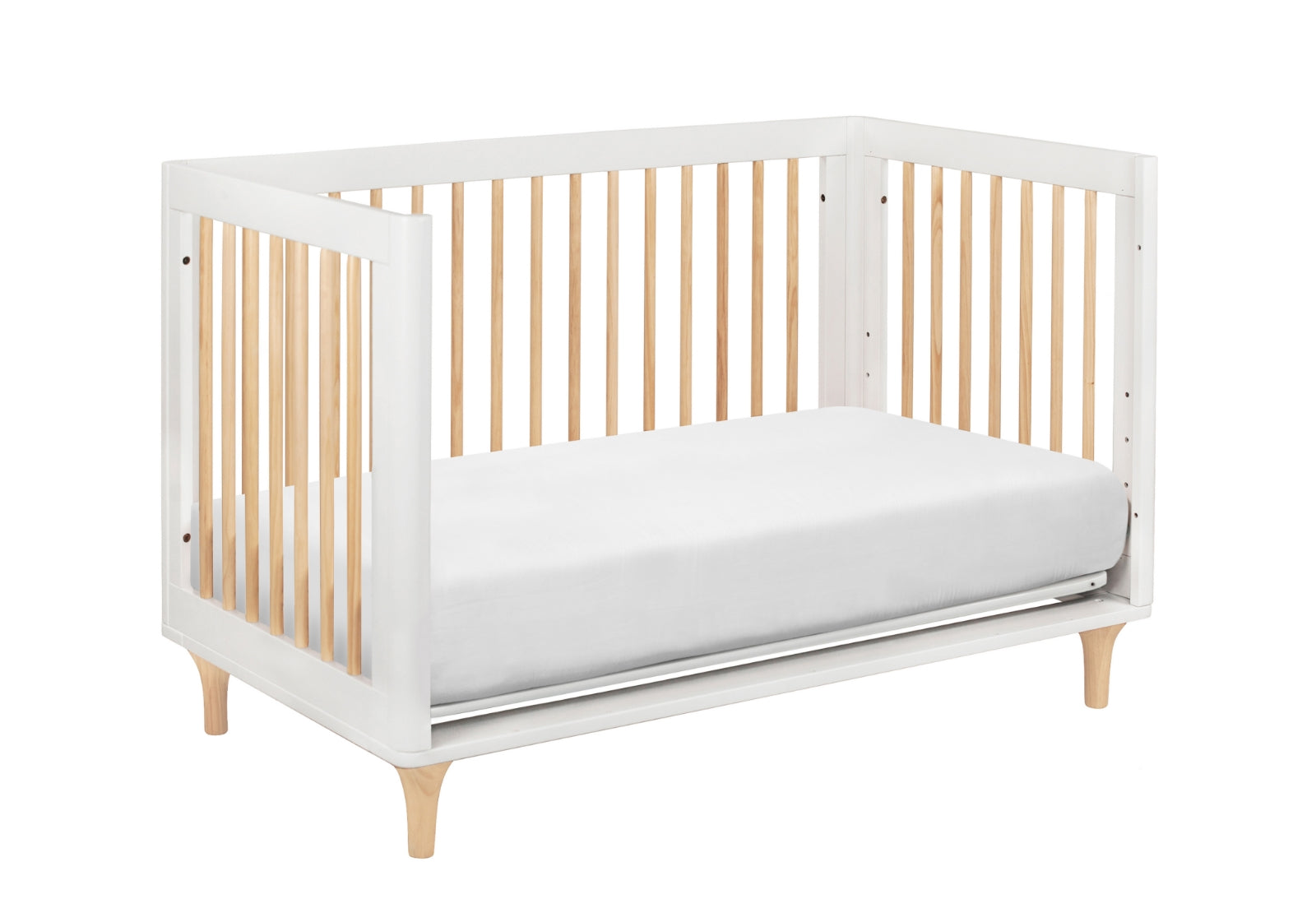 Modern white and wood baby crib with a comfortable mattress on a white background.