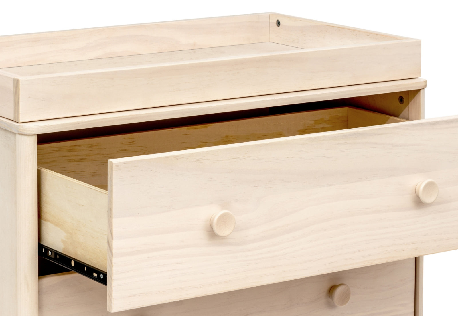 Close-up of a light wood baby changing table with open drawers.