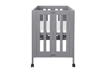 Gray modern baby crib on wheels, featuring a minimalistic design with visible locks and a white mattress.