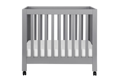 Modern grey baby crib on wheels with a visible mattress, depicted on a white background.