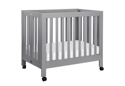 Gray modern baby crib on wheels with visible branding.