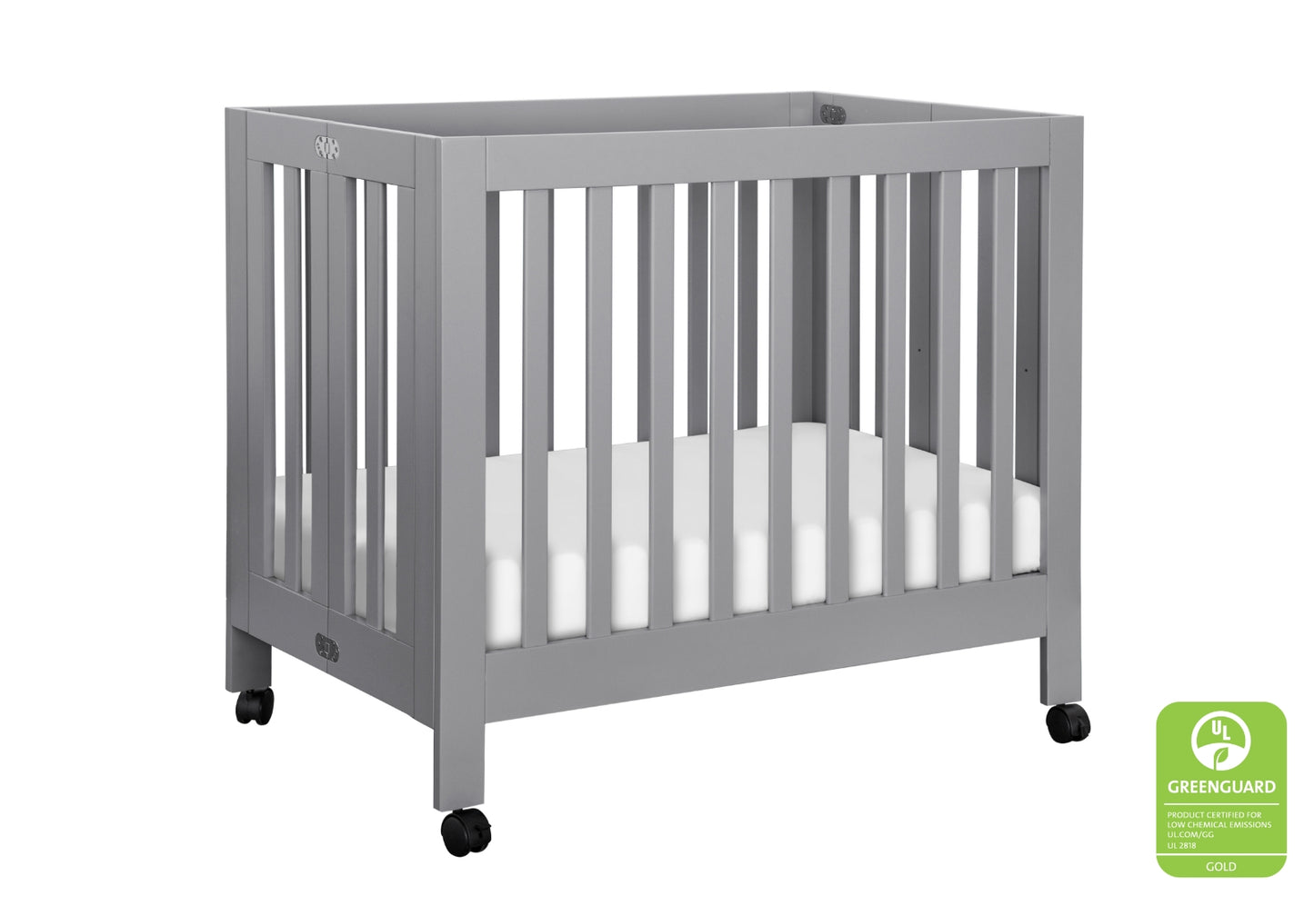 A modern gray baby crib on wheels, featuring the GREENGUARD Gold certification logo.