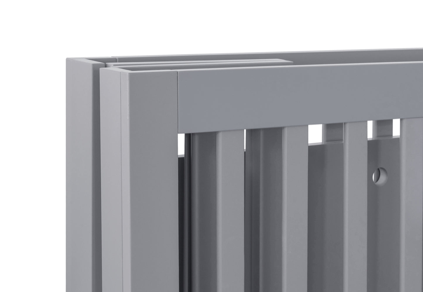 Close-up view of a grey baby crib showcasing its build and finish, no visible text.