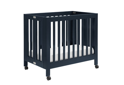 Blue modern baby crib on wheels with a white mattress.