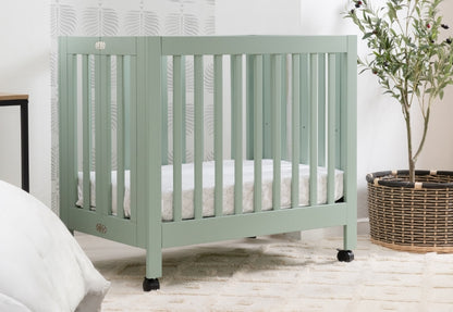 A serene nursery scene featuring a mint green crib labeled with the logo "crib" set against a neat, plant-accented background.