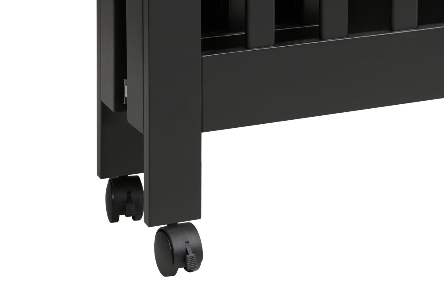 Close-up of a black crib's leg with lockable caster wheels for easy mobility.