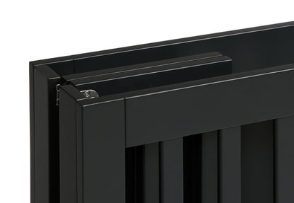 Close-up of a black crib showing detail of corner construction and finish.