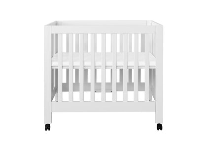 White baby crib on wheels with a visible mattress, isolated on a white background.