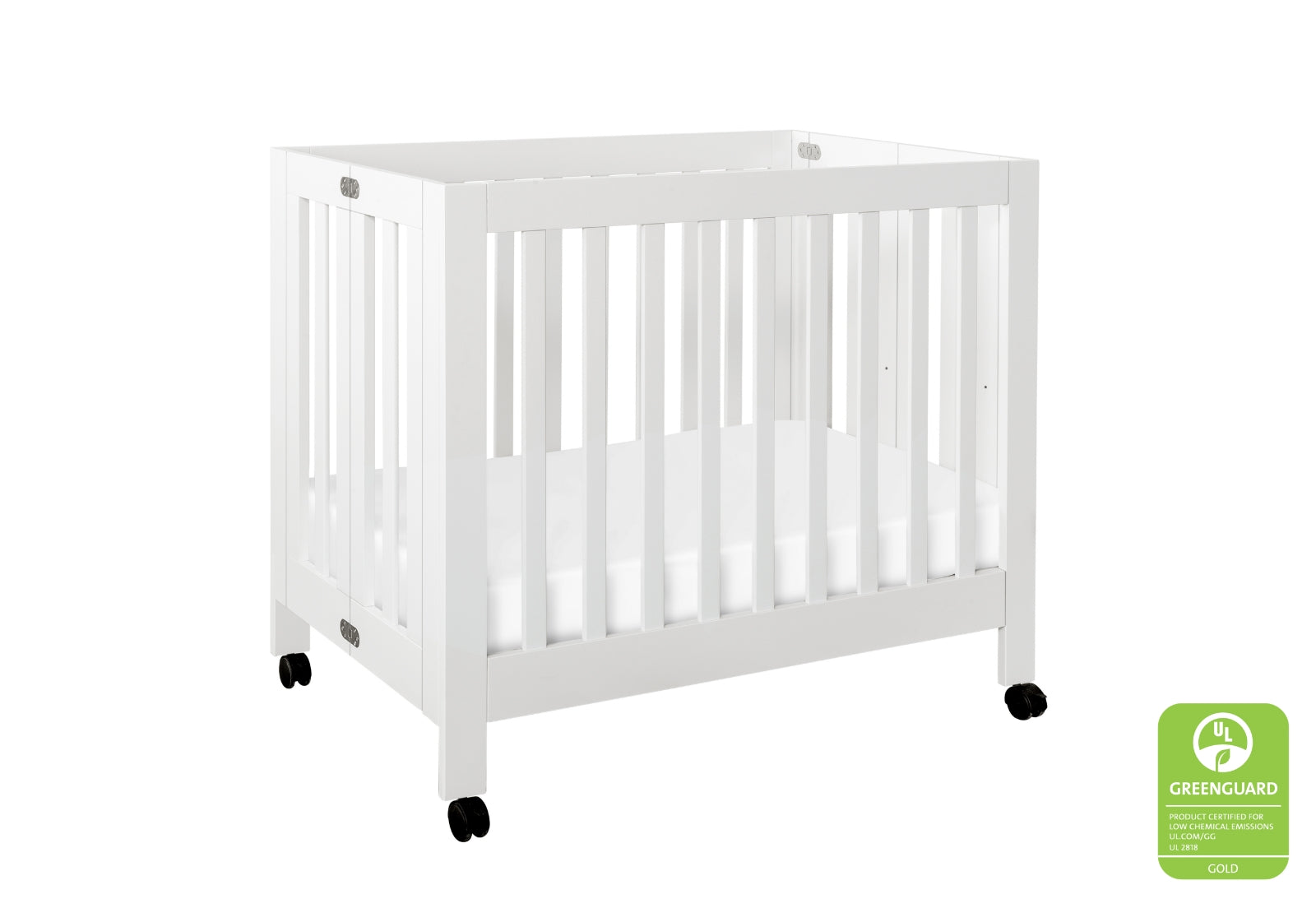 White modern baby crib on wheels with a certification badge displaying "GREENGUARD GOLD."