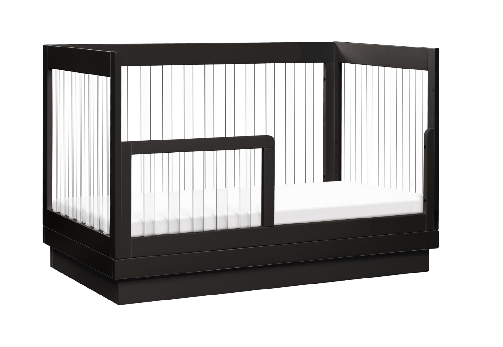 Modern black crib with transparent side panels and an attached toddler bed rail, isolated on a white background.