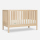 The Newton Galileo Convertible Crib by Newton Baby features light solid beech wood, vertical slats on all sides, and a white mattress—perfect modern nursery furniture—shown against a plain white background. SKIP