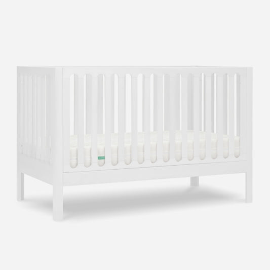The Newton Galileo Convertible Crib by Newton Baby features vertical slats on all sides, a white finish, and stands on four legs with a white mattress—perfect modern nursery furniture for any space.