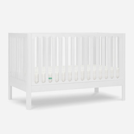 White baby crib with slatted sides and a visible mattress, isolated on a gray background. skip