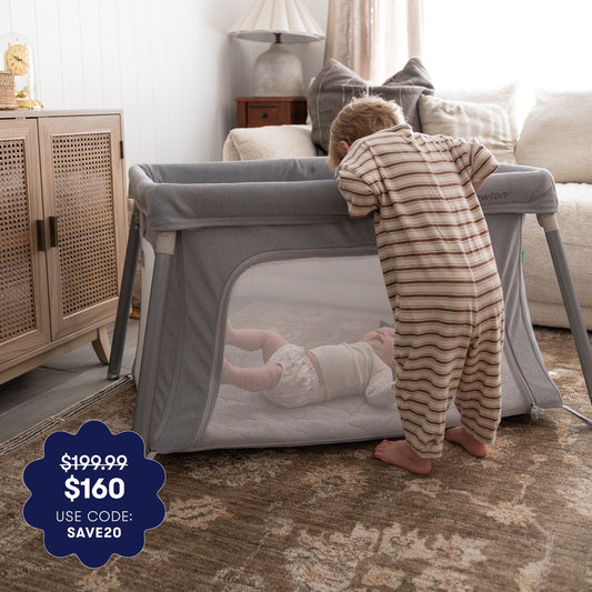 Child playing with a portable crib in a home setting 999-5101-GRY