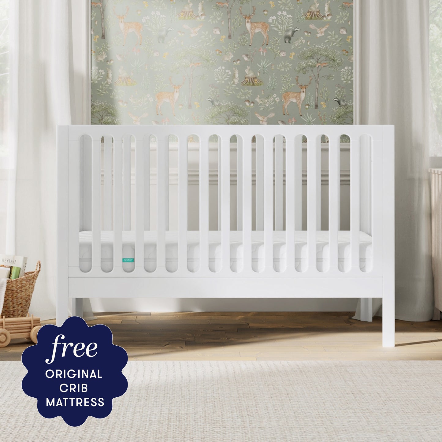 The Newton Galileo Convertible Crib by Newton Baby, made of modern beech wood, sits in a softly lit nursery with animal-themed wallpaper. A dark blue label notes: "Free ORIGINAL CRIB MATTRESS" and easy toddler bed conversion.