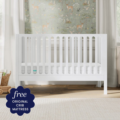 The Newton Galileo Convertible Crib by Newton Baby, made of modern beech wood, sits in a softly lit nursery with animal-themed wallpaper. A dark blue label notes: "Free ORIGINAL CRIB MATTRESS" and easy toddler bed conversion.