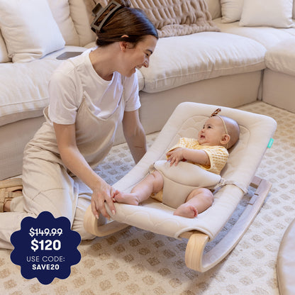A smiling woman kneels by a happy baby in the Newton Baby Rocker by Newton Baby, enjoying a cozy, carpeted living room. Overlay text highlights the price drop from $149.99 to $120 with code SAVE20.