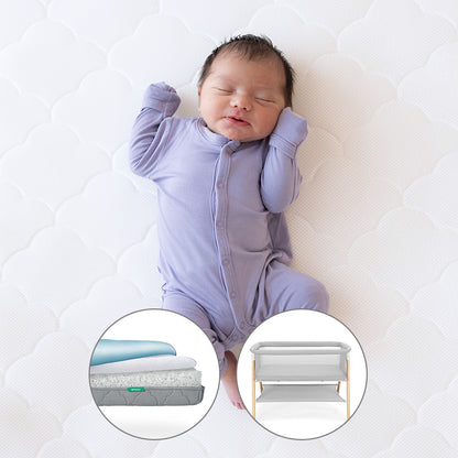 sleeping baby on newton mattress with small circular cutouts of Grey Newton waterproof mattress and essential bassinet on a white background