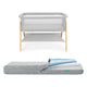 Grey Newton waterproof mattress next to essential bassinet on a white background